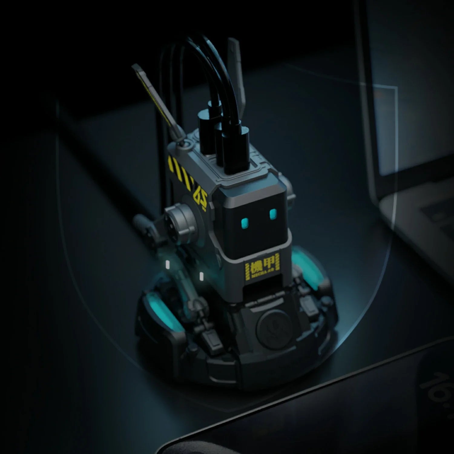 GravaStar Alpha65 GaN 65W Wall Charger Charcoal Gray desktop setup view showing matte black robot body, MECHA logo, ALPHA65 tactical markings, and ice blue RGB eyes.