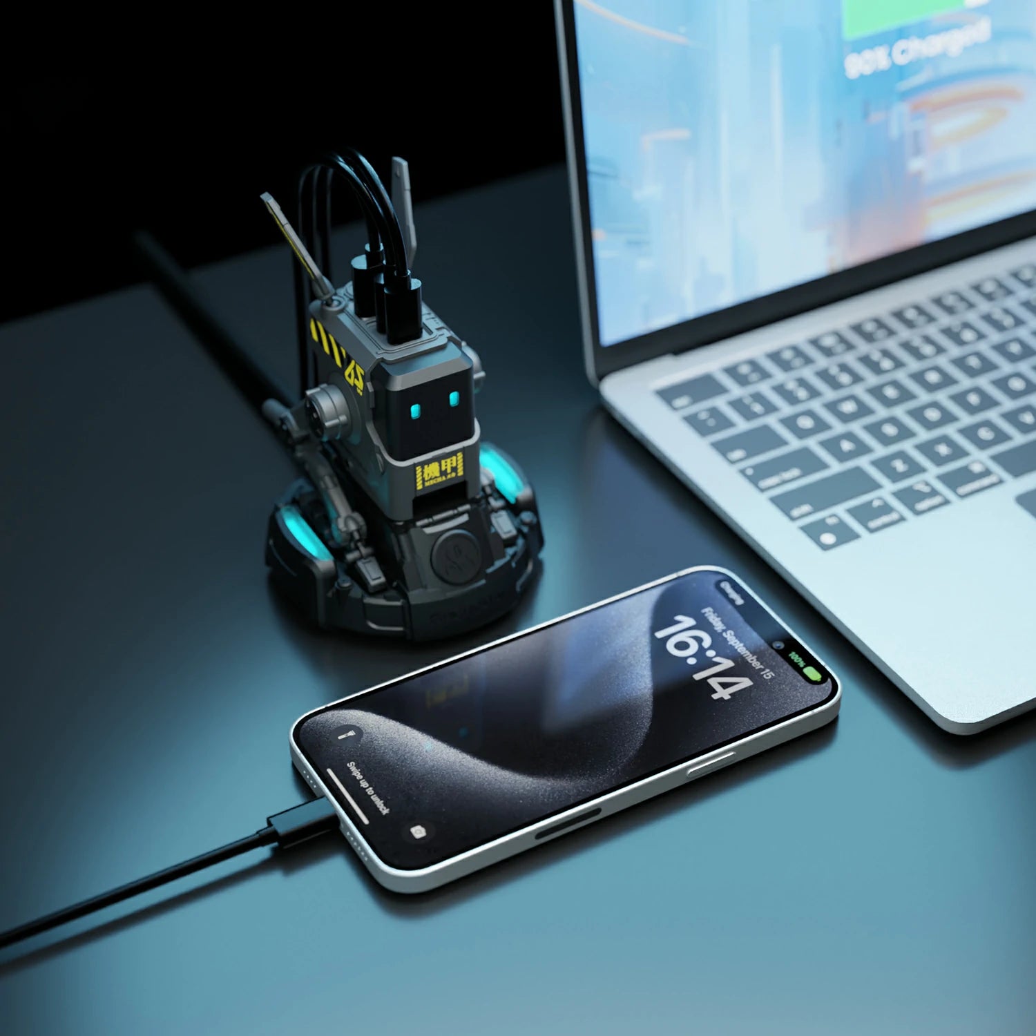 GravaStar Alpha65 GaN 65W Wall Charger Charcoal Gray real-world desktop setup view charging laptop and smartphone simultaneously with 3 USB ports and ice blue RGB eyes.