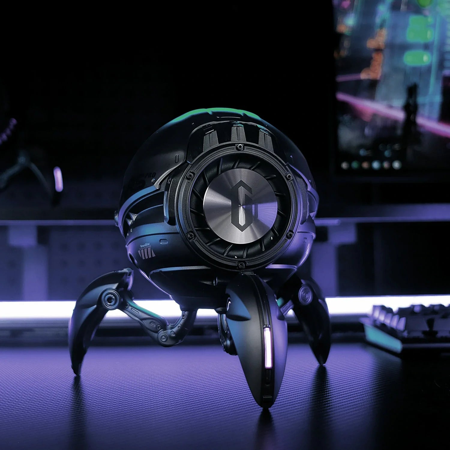 GravaStar Mars Pro Black Bluetooth speaker close-up showcasing passive bass radiator for maximum bass performance, matte black zinc alloy shell, DSP equal-loudness contour, shock-absorbing tripod legs, and ice blue RGB lighting effect.