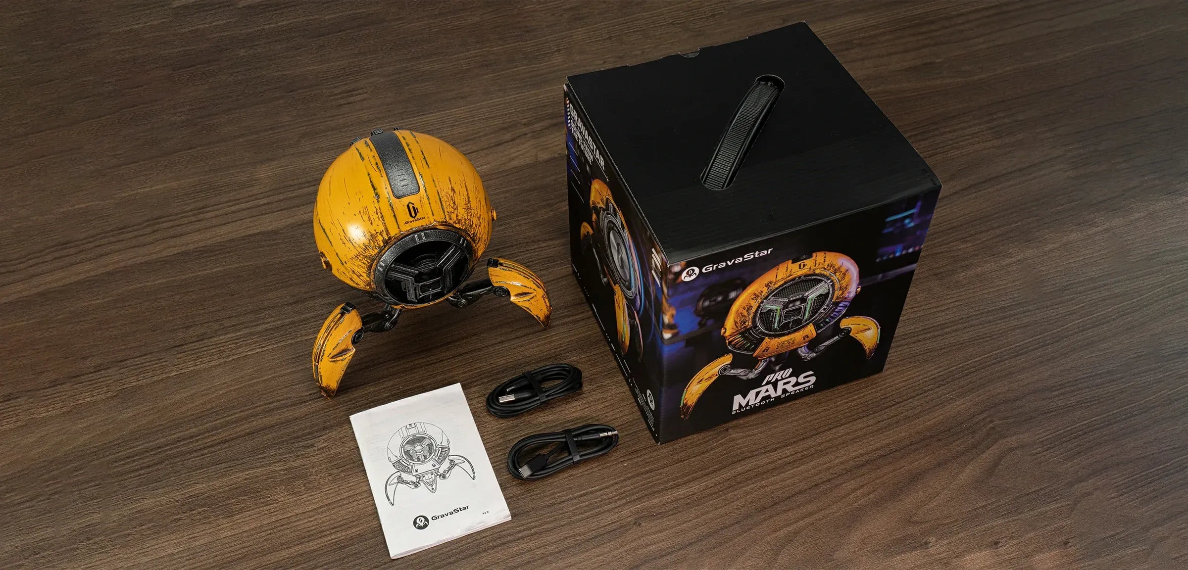 GravaStar Mars Pro series Bluetooth speakers lineup banner showcasing War-Damaged Yellow, Special Edition, Matte Black, and White colorways, each featuring zinc alloy shell, shock-absorbing tripod legs, 20-watt dual speaker system, passive bass radiator, and dynamic RGB lighting.
