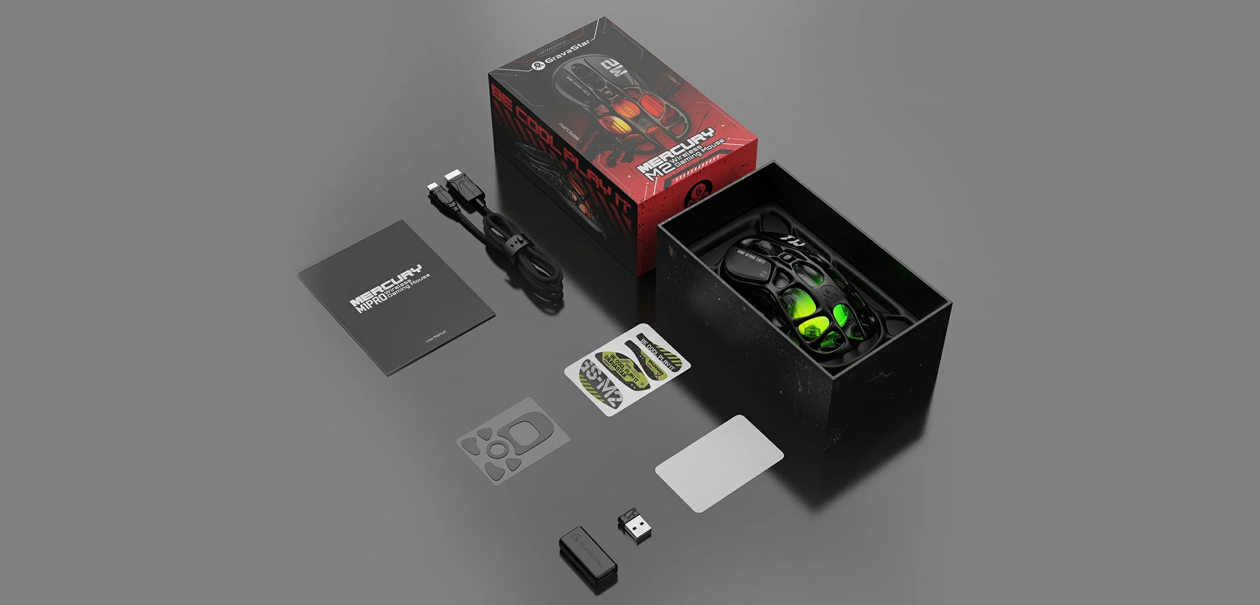 GravaStar Mercury M2 Stealth Black wireless gaming mouse in-the-box accessories diagram featuring wireless mouse, USB paracord charging cable, customized non-slip pads, Teflon foot pads, 1K receiver, USB extender adapter, cleaning cloth, and user manual, powered by PAW3395 26K DPI optical sensor.