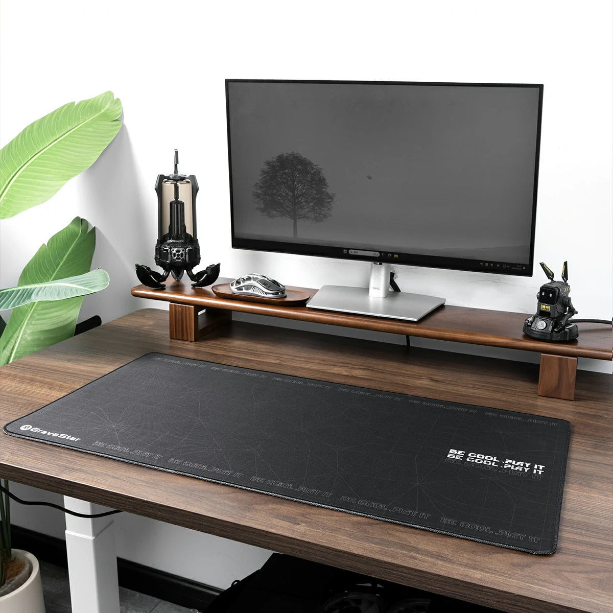 GravaStar Gaming Mouse Pad Black extended cyberpunk deskmat studio setup view featuring waterproof micro-weave surface, BE COOL PLAY IT slogan, Supernova speaker, Mercury mouse, and Alpha65 charger on wooden desk.
