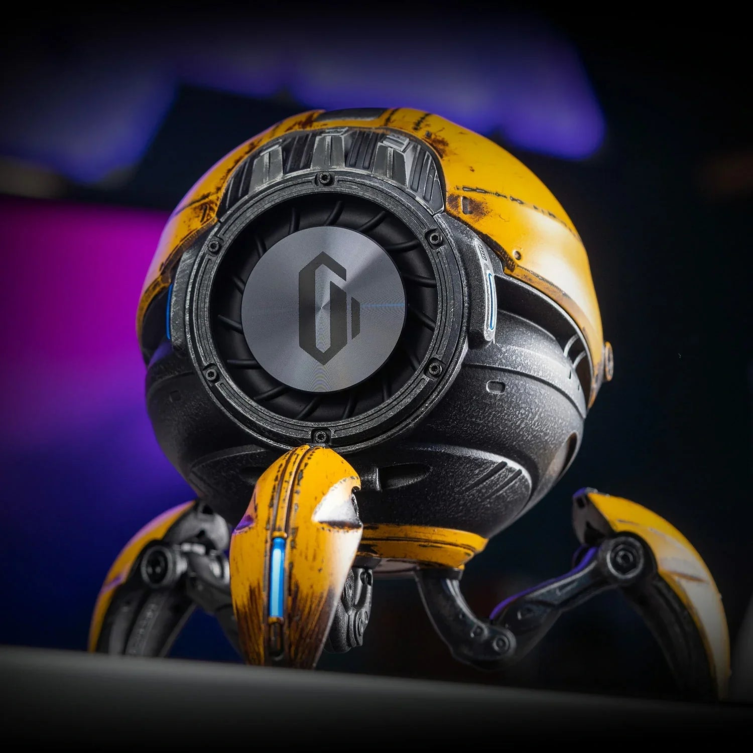 GravaStar Mars Pro Special Edition War-Damaged Yellow handcrafted Bluetooth speaker macro angled view featuring 20W dual speaker system, passive bass radiator, DSP equal-loudness contour, ice blue RGB lighting, and tripod legs, perfect paired with Mercury X Pro Yellow mouse and Mercury K1 Pro Yellow keyboard.