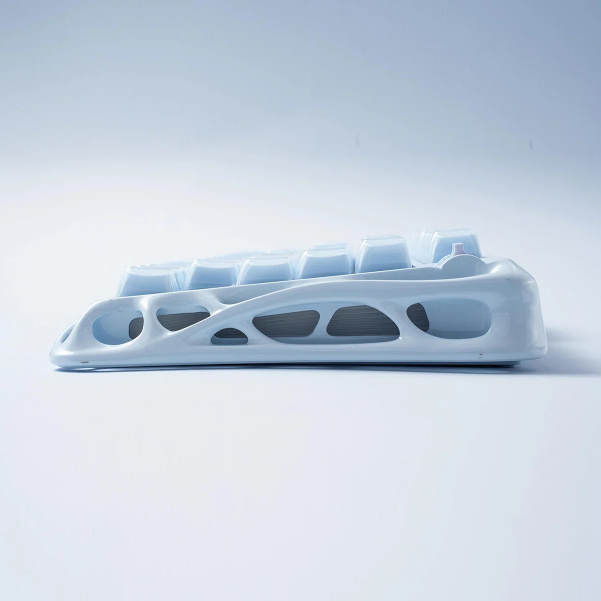 GravaStar Mercury K1 Ice Blue Edition 75% mechanical gaming keyboard side view – Showcasing ice blue skeletonized aluminum chassis profile, gasket-mount structure, and ergonomic tilt angle.
