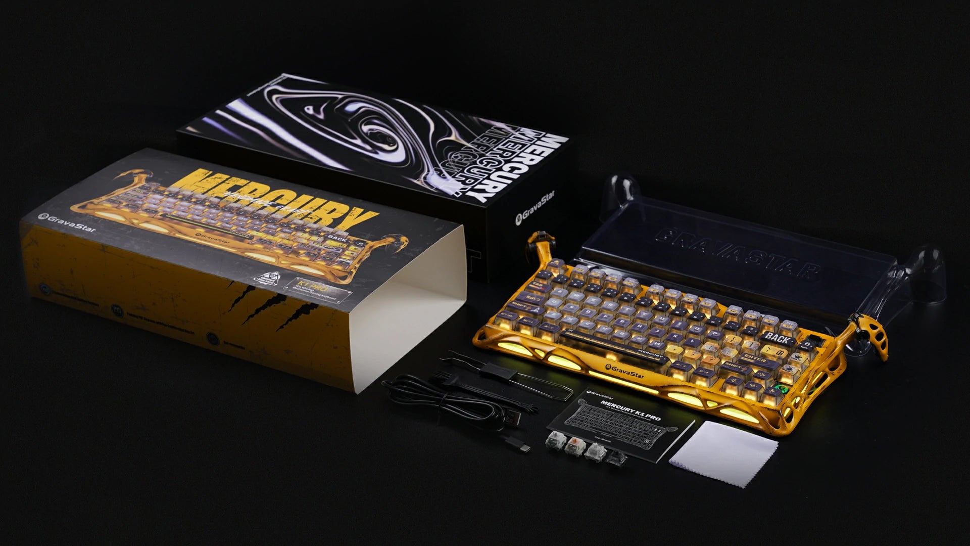 GravaStar Mercury K1 Pro Special Edition Battle-Worn Yellow 75% wireless mechanical gaming keyboard packaging box and accessories view displaying Pudding PBT keycaps, dust cover, Type-C cable, 2.4GHz receiver, 2-in-1 puller, cleaning brush, extra switches, manual, and cleaning cloth.