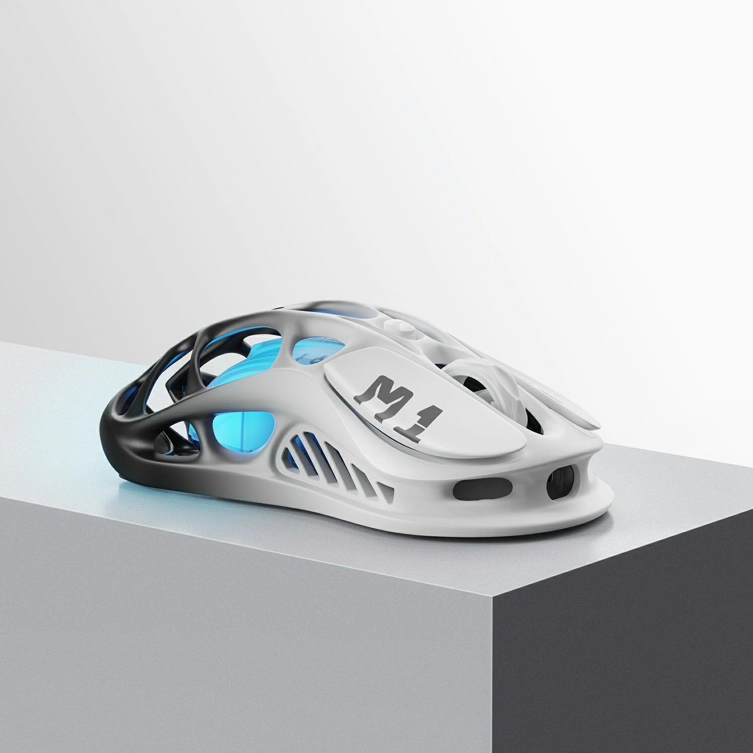 GravaStar Mercury M1 Pro Wireless Gaming Mouse Gradient Black front-right perspective view featuring magnesium alloy skeletal frame, M1 logo on right button, ambidextrous ergonomic shape, and ice blue RGB backlighting.