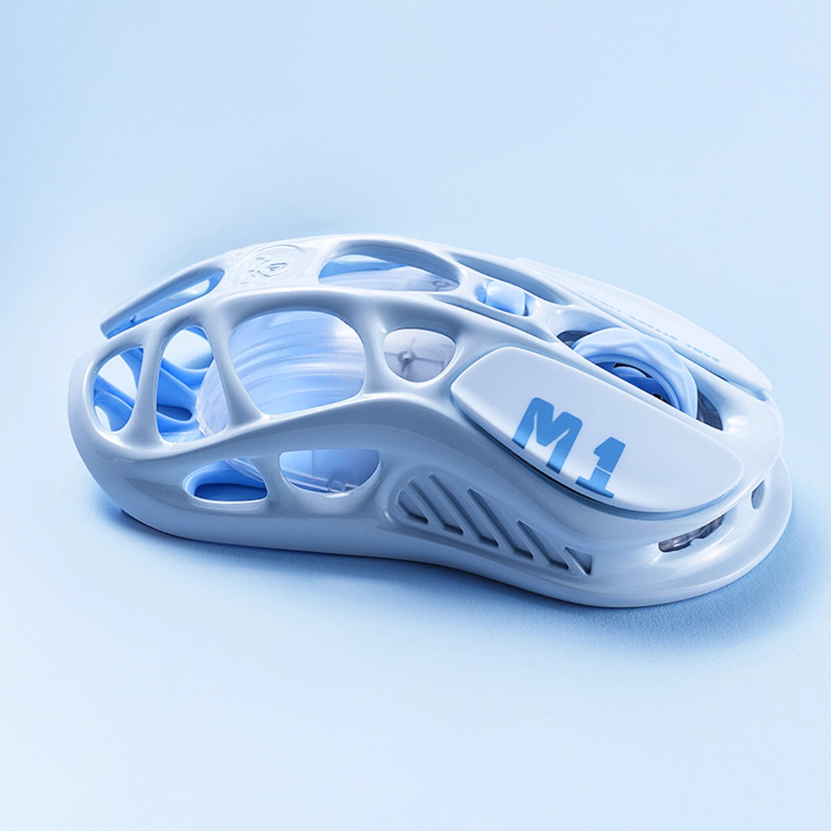 GravaStar Mercury M1 Pro Ice Blue wireless gaming mouse showing 88g magnesium alloy skeletal frame, M1 logo branding, PAW3395 26K DPI sensor, and customizable GlowSync RGB lighting.