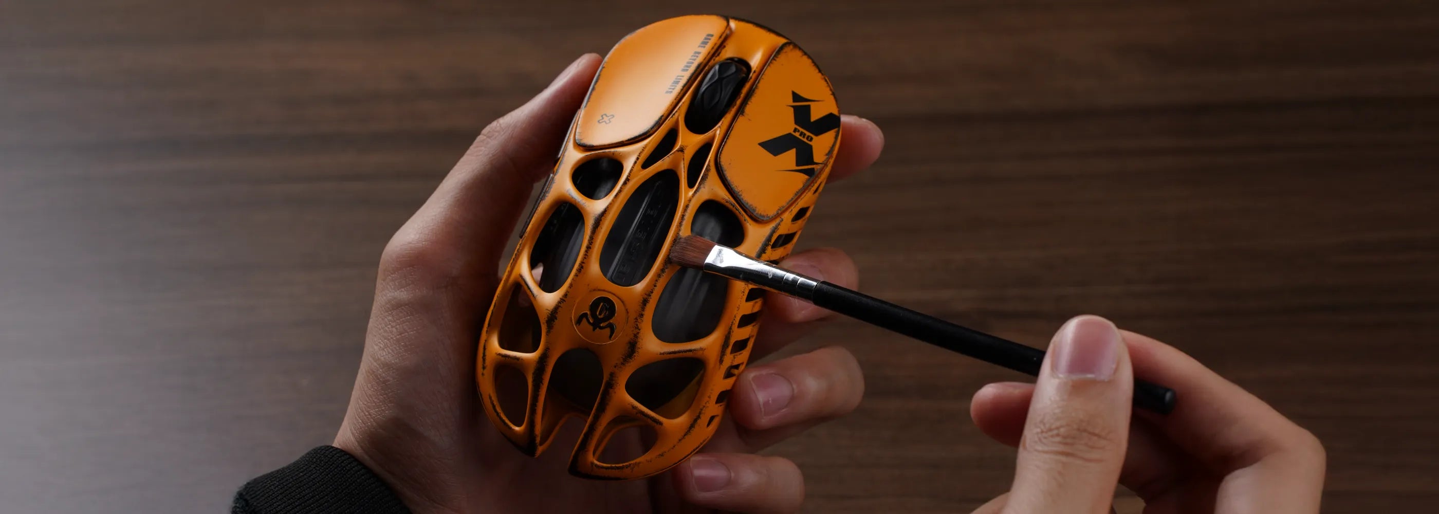 Artisan hand-applying custom battle-worn weathering and finish to the GravaStar Mercury X Pro Special Edition Battle Worn-Yellow magnesium alloy wireless gaming mouse skeleton, highlighting 49g ultralight open-frame design, PixArt PAW 3950 32K DPI sensor, native 8000Hz polling rate, and 0.125ms low latency.