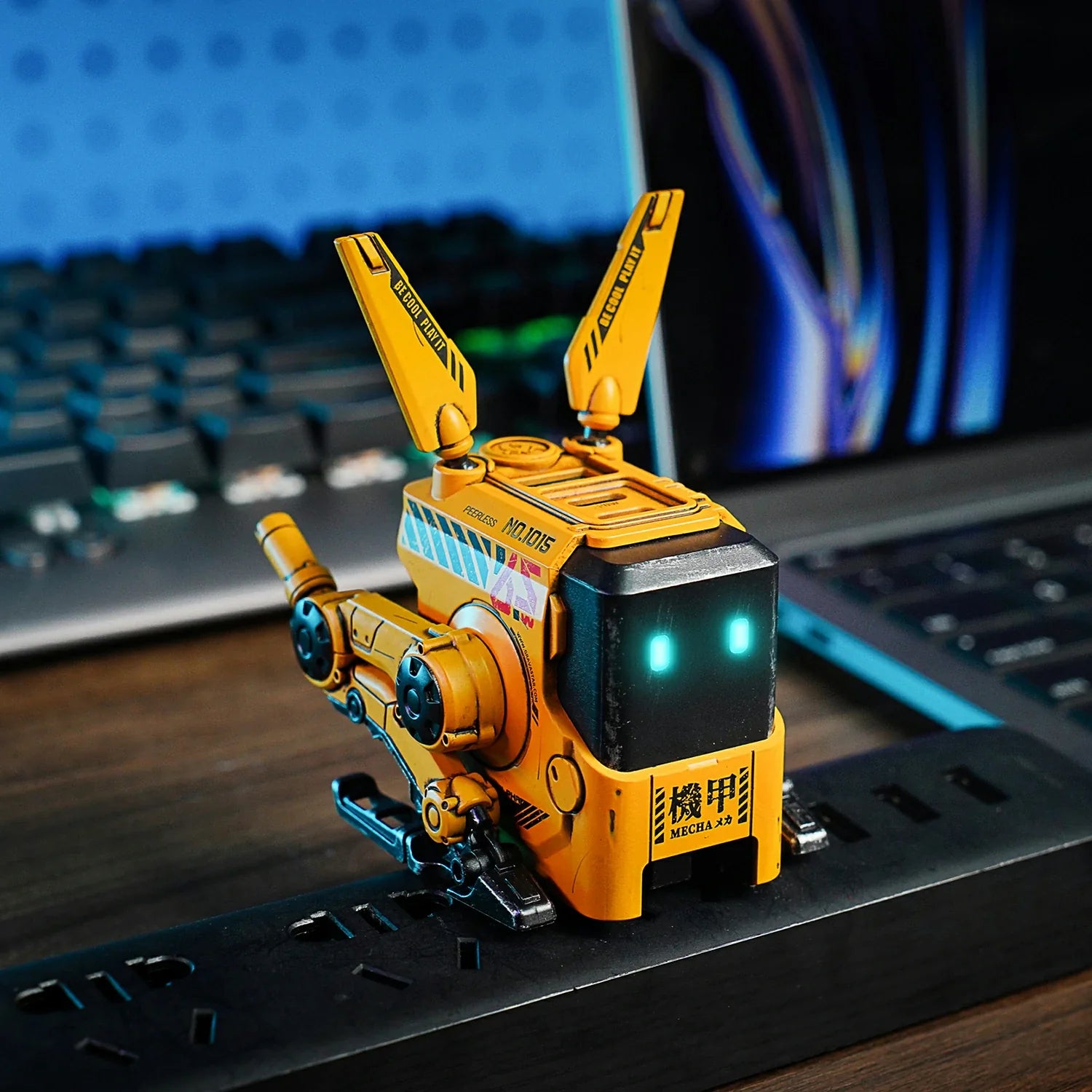 GravaStar Alpha65 War-Damaged Yellow handcrafted 65W GaN fast charger cyberpunk desktop setup view featuring authentic weathered yellow finish, transformable tripod stand, dual antennas, ice blue RGB eyes, and 3 USB ports, perfect paired with Mercury X Pro Yellow mouse and Mercury K1 Pro Yellow keyboard.