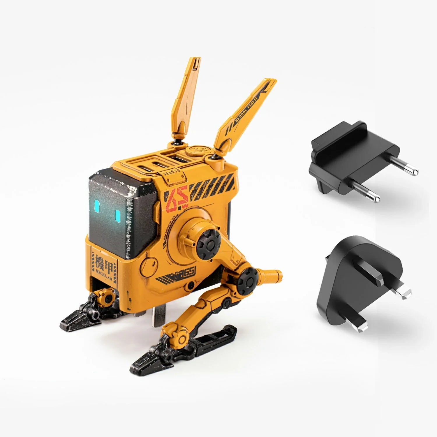 GravaStar Alpha65 War-Damaged Yellow handcrafted 65W GaN fast charger studio standing view with UK and EU plug adapters featuring authentic weathered yellow finish, transformable tripod stand, dual antennas, ice blue RGB eyes, and 3 USB ports, perfect paired with Mercury X Pro Yellow mouse and Mercury K1 Pro Yellow keyboard.
