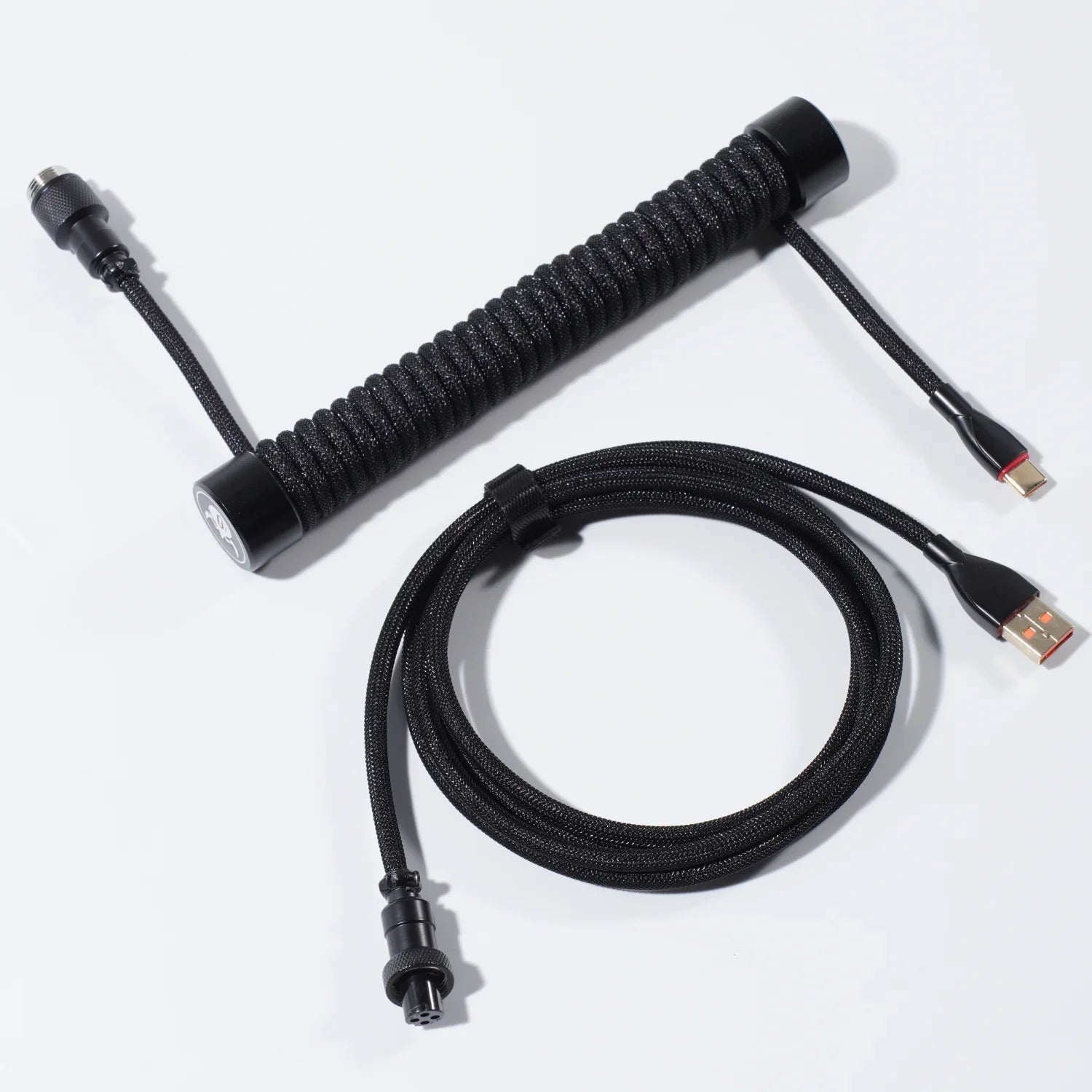 GravaStar Coiled Aviator USB Cable in black studio full component view showing 4-pin detachable aviator connector, TPU EVA double-sleeved braided cable body, gold-plated USB-A to Type-C terminals, perfect paired with Mercury K1 Pro keyboard and GravaStar Gaming Mouse Pad deskmat.