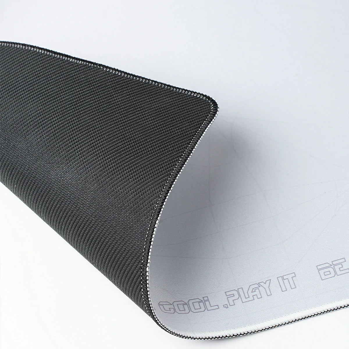 GravaStar Gaming Mouse Pad White studio non-slip base and stitched edges view featuring high-density anti-slip rubber bottom, durable stitched edge border, and waterproof fabric, perfect paired with Mercury V75 Pro White keyboard and Mercury M1 Pro Silver Mist gaming mouse.