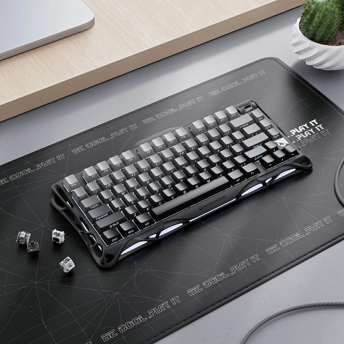 GravaStar Mercury K1 Gradient Black – Top-down desk setup view of 75% wireless mechanical gaming keyboard with coiled aviator cable, extra switches, aluminum alloy gradient frame, and dual RGB backlight.