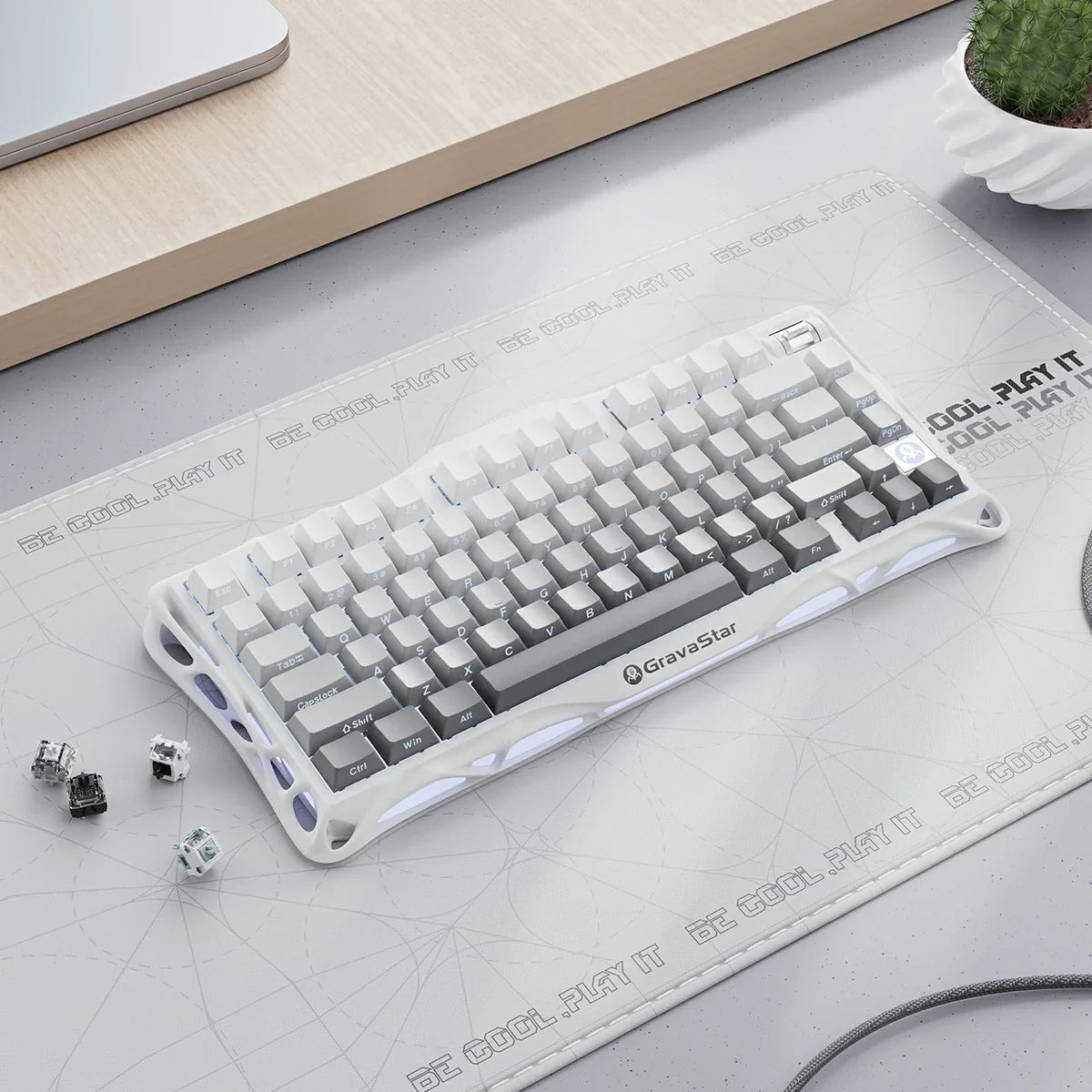 GravaStar Mercury K1 Gradient White – Top-down desk setup view of 75% wireless mechanical gaming keyboard with aluminum alloy exoskeleton frame, hot-swap linear switches, coiled aviator cable, and extra switches.