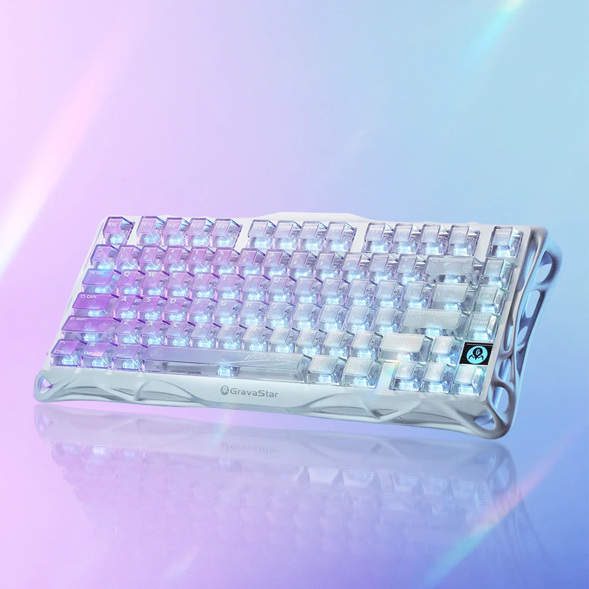 GravaStar Mercury K1 Lite Crystal Aurora Edition 75% mechanical gaming keyboard – Side angle view featuring transparent PC chassis with GravaStar branding, purple and blue translucent keycaps, and dynamic RGB backlighting reflected on a slick surface.