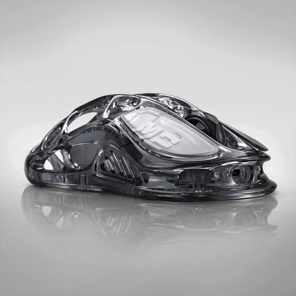 GravaStar Mercury M2 Transparent Black wireless gaming mouse right profile view with surface reflection – Highlighting see-through crystal housing, skeletal frame design, 2024 Red Dot Award design, PAW3395 26K DPI sensor, and Kailh 80M micro-switches, perfect paired with Mercury K1 Lite Transparent Black keyboard and Mars Pro Black speaker.